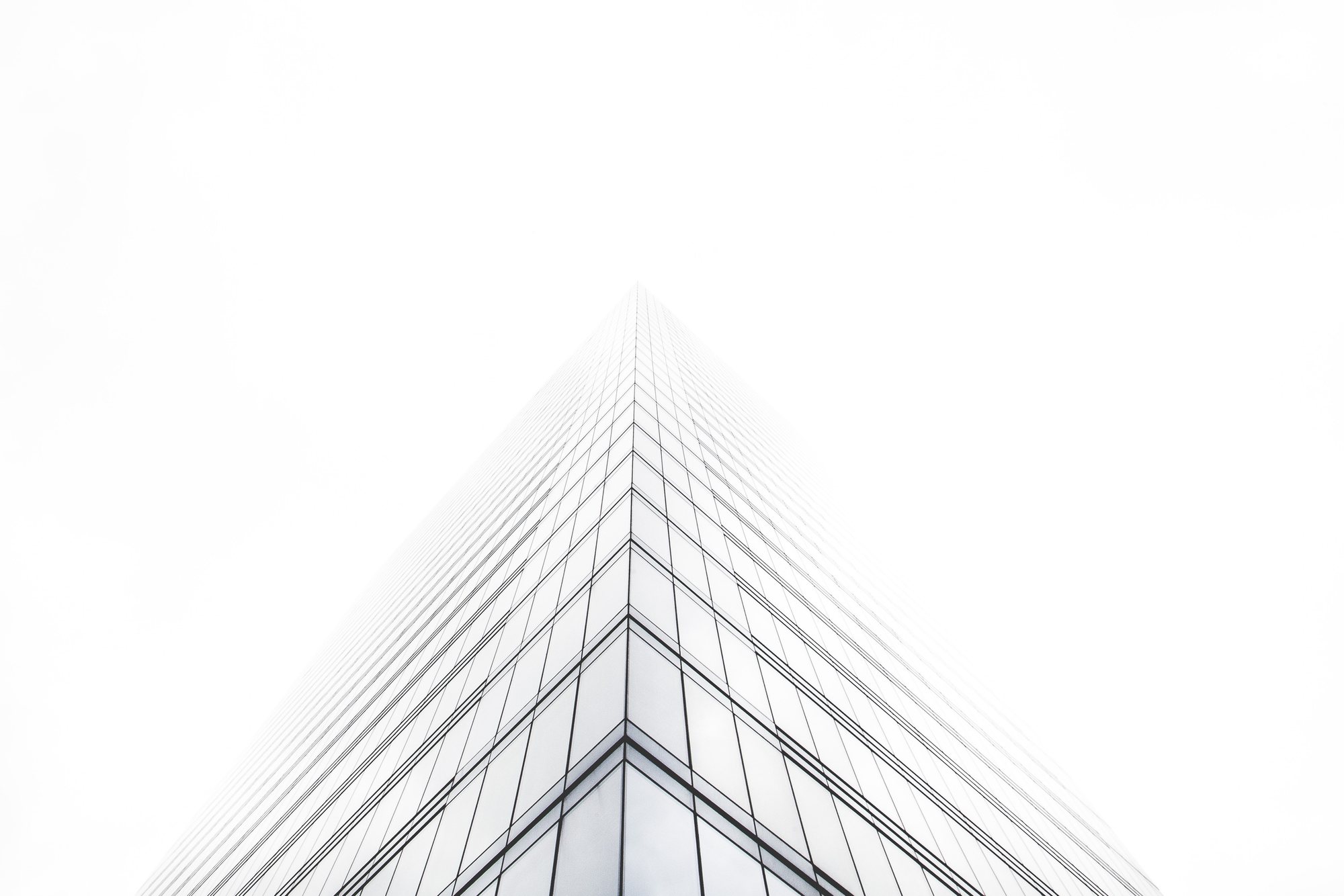 A steel-and-glass tower photographed from below against a bright sky